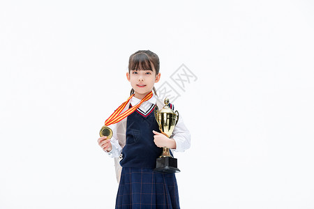 小学生得奖背书包的小女孩手里拿着奖杯背景