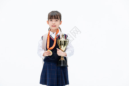 女生获得奖牌背书包的小女孩手里拿抱奖杯背景