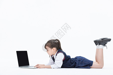小女孩趴着使用笔记本电脑图片