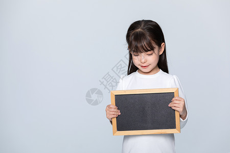小女低头看黑板背景图片