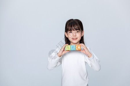 儿童节字母拿着字母方块的小女孩背景