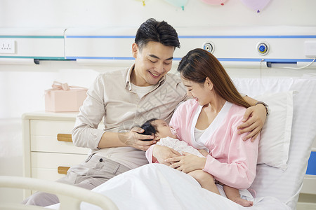 医院产房年轻夫妻和新生婴儿宝宝温馨互动高清图片