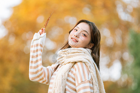 秋季可爱女孩手拿枫叶的背景