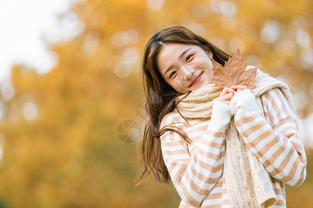 秋季可爱女孩手拿枫叶的背景图片