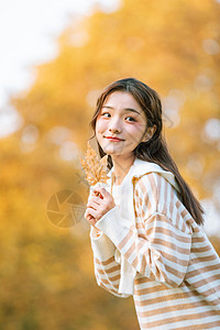 手拿树叶的秋季可爱女孩背景图片