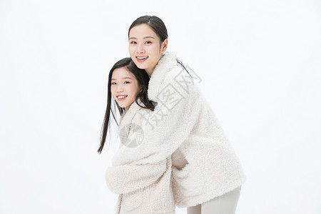 和母亲抱在一起穿着白色毛衣的母女抱在一起背景
