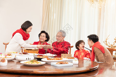 新春年夜饭团圆饭妈妈为长辈盛汤背景图片