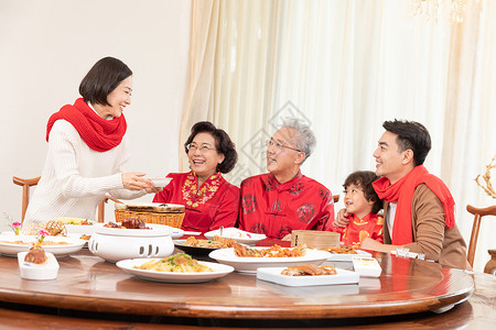 新春年夜饭团圆饭妈妈为长辈盛汤背景图片