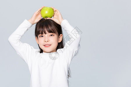 平衡膳食小女孩头上顶着青苹果背景