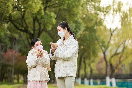 大衣冬天服饰母女两人带着口罩在公园背景