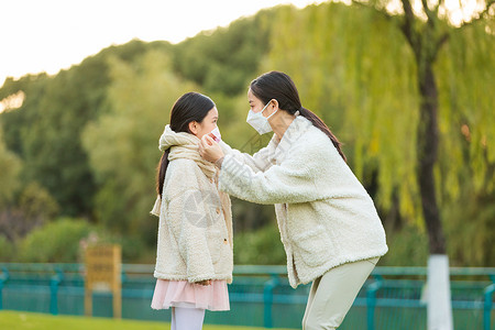 大衣冬天服饰母女两人带着口罩在公园背景