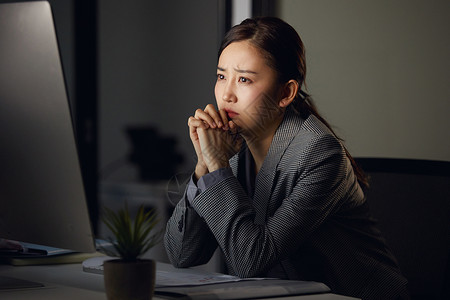 熬夜加班的白领看着电脑发呆苦恼图片