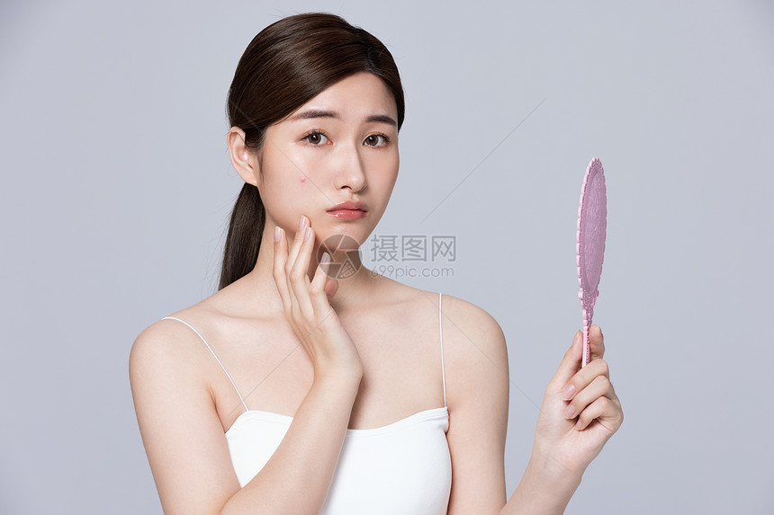 女性脸上长痘痘不知所措图片