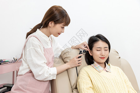 美容师给美女顾客掏耳朵背景图片