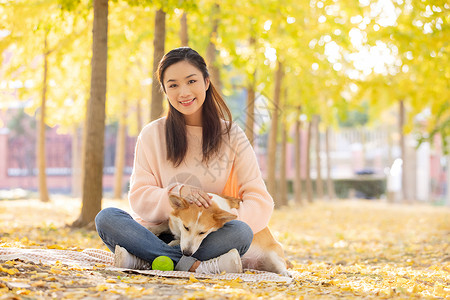 抱着球的狗女性抱着宠物坐在地毯上背景