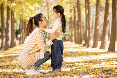 秋季温馨妈妈蹲下和女儿对视高清图片