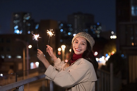 快乐放粽毛笔字冬季夜晚美女天台上放烟花仙女棒背景