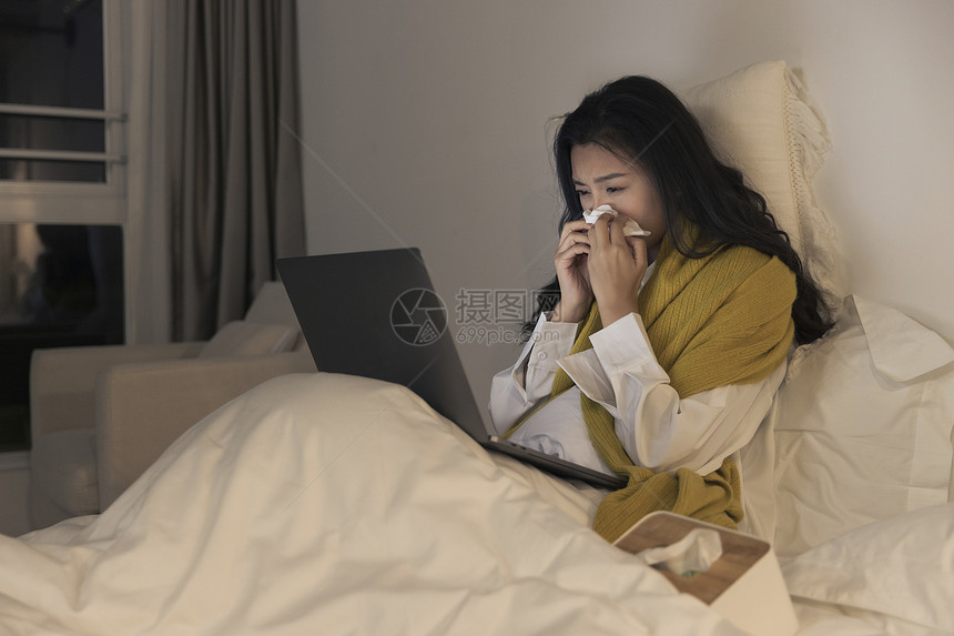 夜晚女性躺床上看笔记本电脑图片