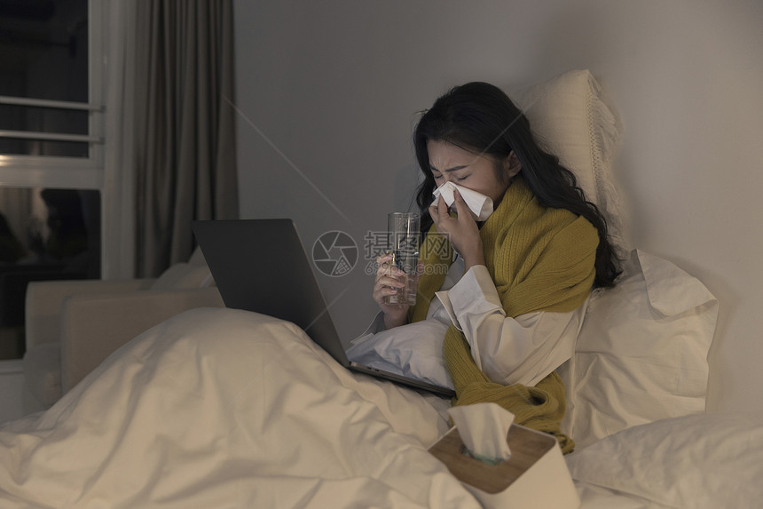 夜晚女性躺床上看笔记本电脑图片