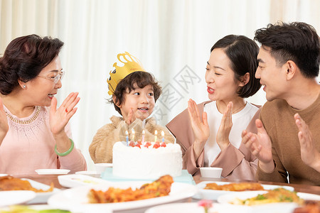 一家人欢乐地为小男孩庆祝生日高清图片