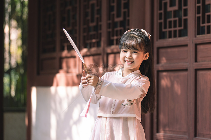 汉服中国风儿童拿扇子逛公园玩耍图片