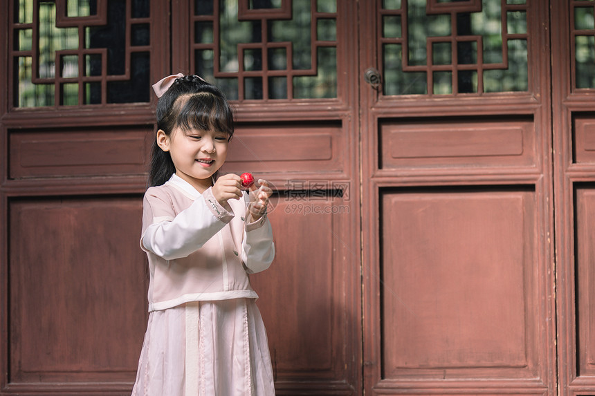 汉服中国风儿童拿扇子逛公园玩耍图片