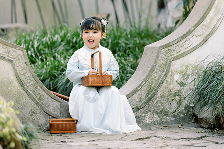 蹲着的古风女孩中国风儿童汉服小女孩提篮子背景