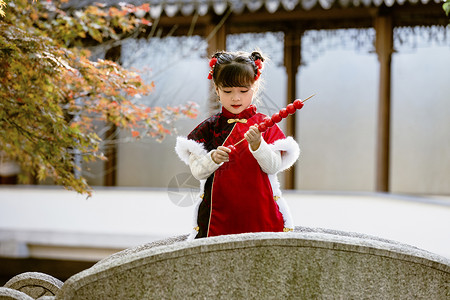 糖葫芦和女孩中国风儿童新年拿糖葫芦逛公园背景