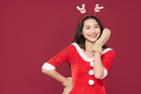 麋鹿头饰甜美女性戴手套过圣诞背景