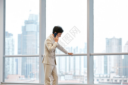 办公室内商务男士使用手机打电话沟通图片