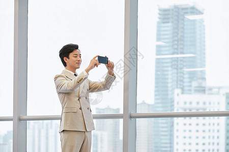 企业家照片使用手机拍照的商务男士建筑设计师背景