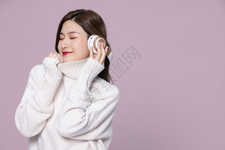 韩式皮肤管理穿着毛衣的美女带耳机听音乐背景
