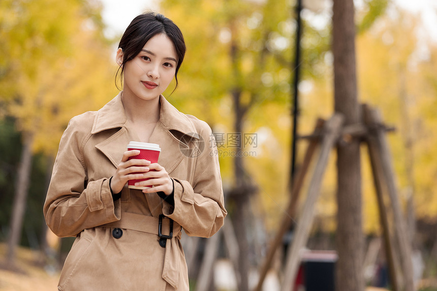 户外手捧咖啡的知性女青年图片