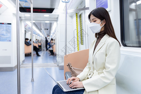 乘坐地铁的女性用笔记本电脑办公图片