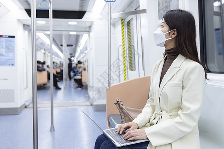 乘坐地铁的女性使用电脑办公图片