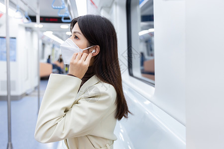 乘坐地铁的女性使用耳机听音乐图片