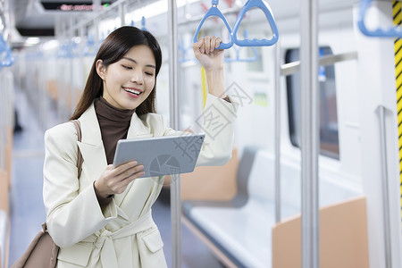 旅行笑容女生在地铁上开心地看着平板电脑背景