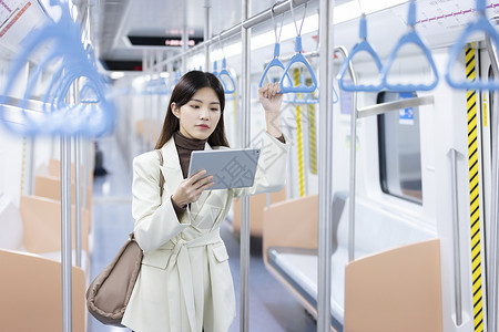 女性在空旷的地铁上使用平板图片
