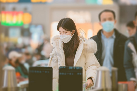 冬天羽绒服戴着口罩排队检票进站的女性背景