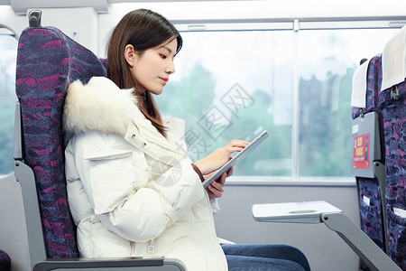 女性坐在火车上使用平板电脑高清图片