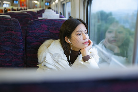 坐在火车上看车窗外思考的女性高清图片