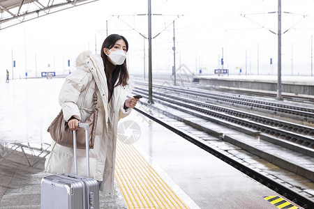 高铁等车拉着行李箱戴口罩在站台等车的女性背景