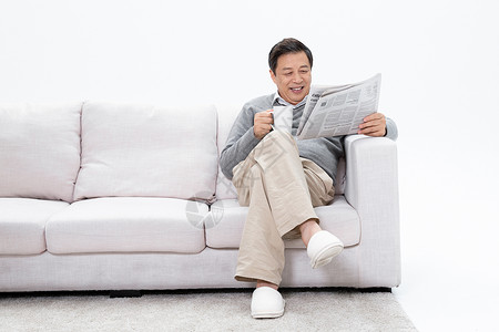 沙发上看报老人坐在沙发上享受咖啡看报纸背景