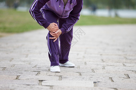 膝盖运动老奶奶逛公园腿部膝盖疼痛特写背景