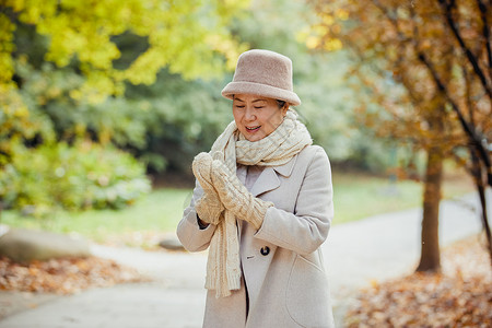 老人保暖秋冬季节老奶奶逛公园戴手套保暖背景