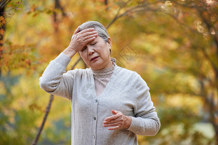 预防心脑血管疾病老年人老奶奶戴口罩公园里头疼背景