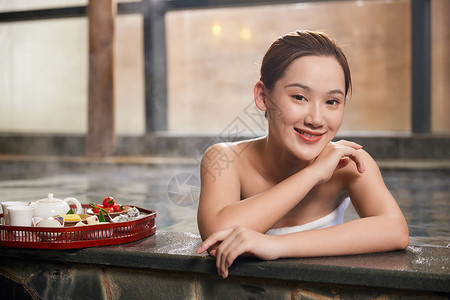 年轻美女享受温泉泡汤背景图片