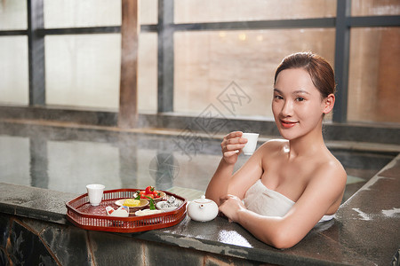 年轻美女泡温泉喝茶图片