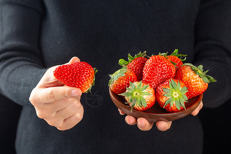 手里拿着草莓水果图片