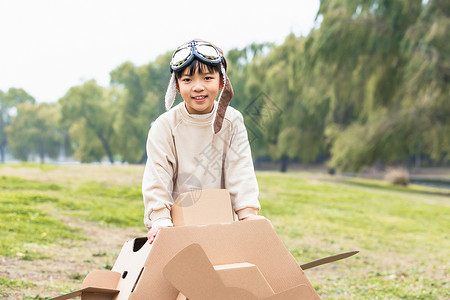 秋季小男孩抱着纸盒箱飞机嬉戏图片